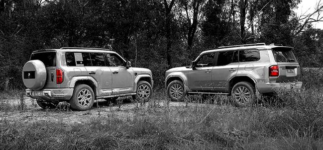The image shows two sturdy, off-road vehicles parked in a grassy, forested area, with one vehicle slightly ahead and the other behind.

AI-generated content may be incorrect.