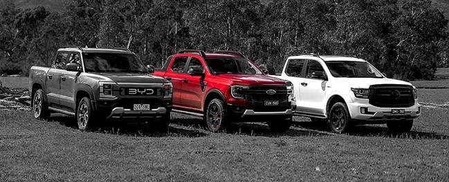 The image shows four different trucks, two red and two white, parked in a grassy area with a mountainous background.

AI-generated content may be incorrect.